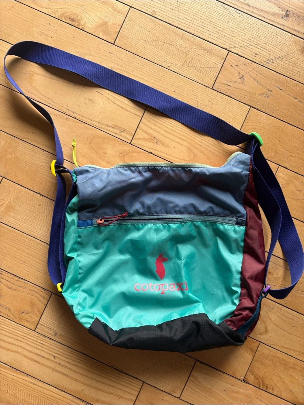 cotopaxi teal multicolor crossbody messenger bag with navy strap